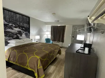 a hotel room with a bed and a desk at Super 8 by Wyndham Charleston WV in Charleston
