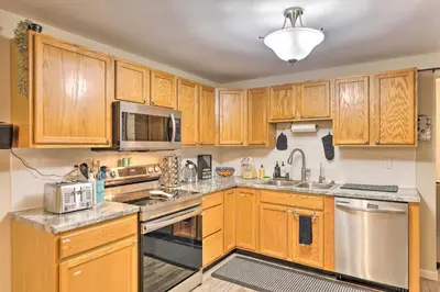 a kitchen with wooden cabinets and stainless steel appliances at Single-Story Home in Fairborn with Yard and Patio! in Fairborn
