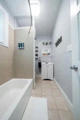 a white bathroom with a tub and a sink at Robin's Nest - Miami U, Weddings or Spooky Nook! in Hamilton