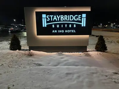 a sign for a hotel in the snow at night at Staybridge Suites - Cincinnati East - Milford by IHG in Cincinnati