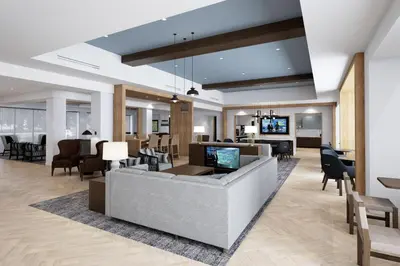 a lobby with a couch and chairs and a television at Staybridge Suites - Cincinnati East - Milford by IHG in Cincinnati