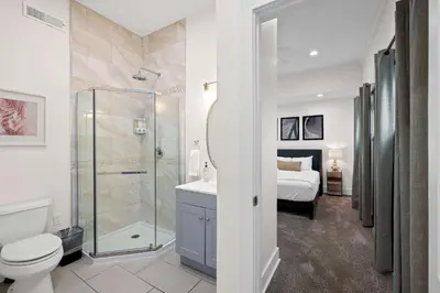 a bathroom with a toilet and a shower and a bed at Spacious Home Near Ark, Perfect for 12 Guests in Williamstown