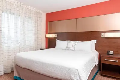 a hotel room with a large bed and red walls at Residence Inn by Marriott Akron South/Green in Akron