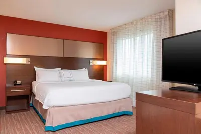 a hotel room with a bed and a flat screen tv at Residence Inn by Marriott Akron South/Green in Akron