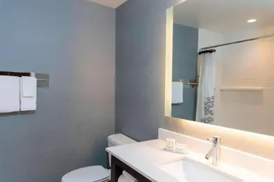 a bathroom with a sink and a toilet and a mirror at Residence Inn by Marriott Akron South/Green in Akron