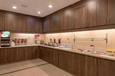 a kitchen with wooden cabinets and a counter with food at Residence Inn by Marriott Akron South/Green in Akron