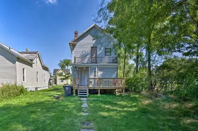 a white house with a porch and a deck at Charming Fort Wayne Home about 1 Mi to Downtown! in Fort Wayne