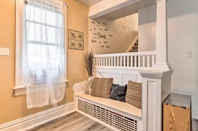 a room with a staircase with a bench and a window at Charming Fort Wayne Home about 1 Mi to Downtown! in Fort Wayne