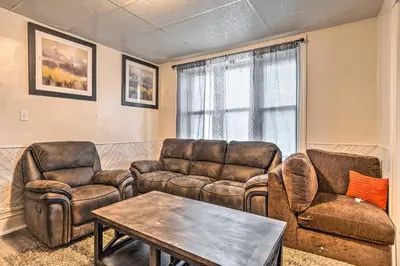 a living room with leather furniture and a table at Charming Fort Wayne Home about 1 Mi to Downtown! in Fort Wayne
