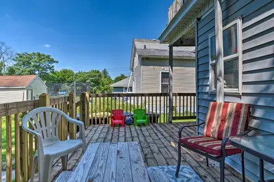 a patio with two chairs and a wooden table at Charming Fort Wayne Home about 1 Mi to Downtown! in Fort Wayne