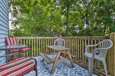 a patio with two chairs and a wooden table and chairs at Charming Fort Wayne Home about 1 Mi to Downtown! in Fort Wayne