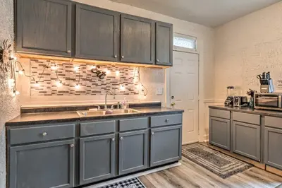 a kitchen with gray cabinets and a sink at Charming Fort Wayne Home about 1 Mi to Downtown! in Fort Wayne
