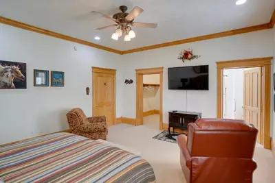 a bedroom with a bed and a flat screen tv at Spacious McArthur Home Private Hot Tub and Pond! in Hamden