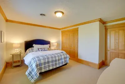a bedroom with a bed with a blue headboard at Spacious McArthur Home Private Hot Tub and Pond! in Hamden