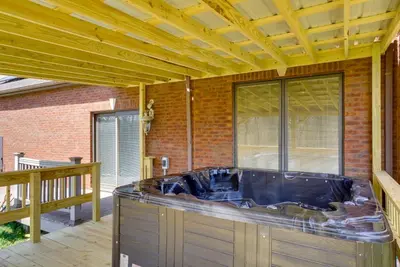 a large jacuzzi tub sitting on a patio at Spacious McArthur Home Private Hot Tub and Pond! in Hamden