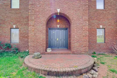 a brick building with a blue door on it at Spacious McArthur Home Private Hot Tub and Pond! in Hamden