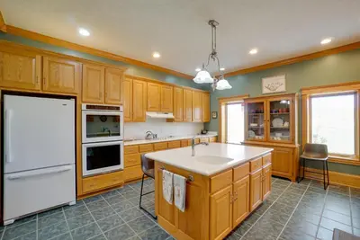 a kitchen with wooden cabinets and a white refrigerator at Spacious McArthur Home Private Hot Tub and Pond! in Hamden