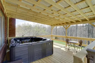 a patio with a stove on a wooden deck at Spacious McArthur Home Private Hot Tub and Pond! in Hamden