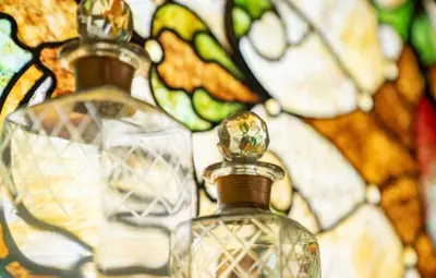 a close up of a bottle of perfume next to a stained glass window at The Victorian Guesthouse Bed & Breakfast in Delphos