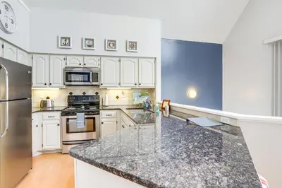 a kitchen with white cabinets and a granite counter top at Family-Friendly Port Clinton Home with Private Deck in Port Clinton
