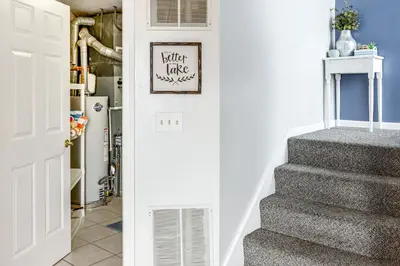 a hallway with stairs and a picture on the wall at Family-Friendly Port Clinton Home with Private Deck in Port Clinton