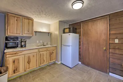 a kitchen with a white refrigerator and wooden cabinets at Lynn Dog-Friendly Abode with Mountain Views! in Hagerhill