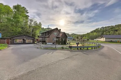 a house on a road with a bench in the middle at Lynn Dog-Friendly Abode with Mountain Views! in Hagerhill