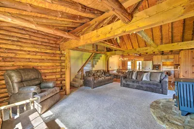 a living room with leather furniture in a log cabin at Rustic Zanesville Getaway with Expansive Yard! in Zanesville