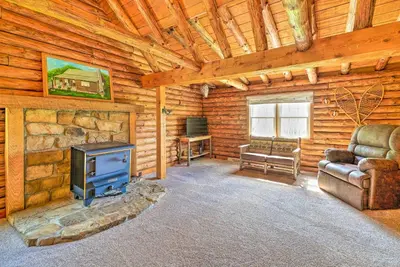 a living room with a stove in a log cabin at Rustic Zanesville Getaway with Expansive Yard! in Zanesville