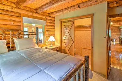 a bedroom with a bed in a log cabin at Rustic Zanesville Getaway with Expansive Yard! in Zanesville