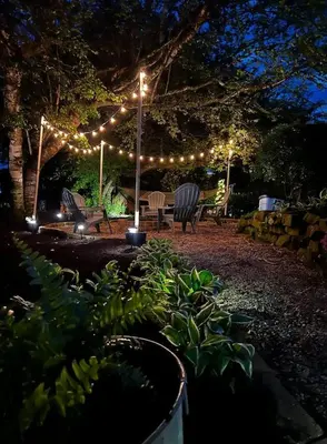 a patio with lights and a table and chairs at night at The Carriage House 1836 in Millersburg