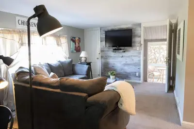 a living room with a leather couch and a television at The Carriage House 1836 in Millersburg
