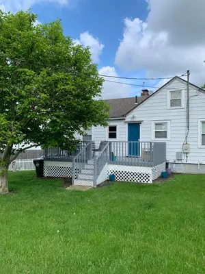 a white house with a porch and a tree at Cherry717 in Fairborn