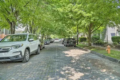 a cobblestone street with parked cars and trees at Blue Yonder Half Mi to Childrens Hospital in Columbus