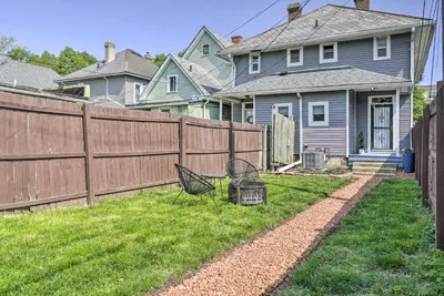 a yard with a fence and a chair in the grass at Blue Yonder Half Mi to Childrens Hospital in Columbus