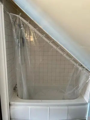 a bath tub with a shower curtain over it at Grandma's Attic in Lakewood