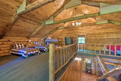 a log cabin with a bedroom and a balcony at The Red Pine Cabin with Private Pond and Dock! in Loudonville