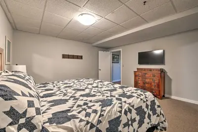 a bedroom with a bed and a flat screen tv at The Red Pine Cabin with Private Pond and Dock! in Loudonville