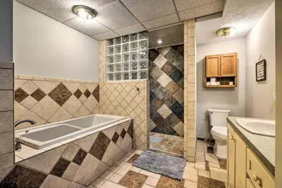 a bathroom with a tub and a toilet and a sink at The Red Pine Cabin with Private Pond and Dock! in Loudonville