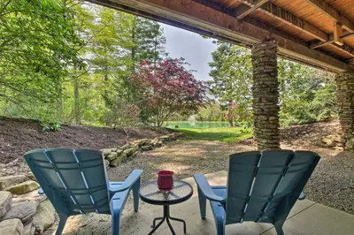two chairs and a table on a patio at The Red Pine Cabin with Private Pond and Dock! in Loudonville