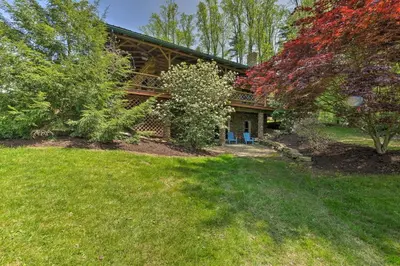 a house with a porch and a yard at The Red Pine Cabin with Private Pond and Dock! in Loudonville