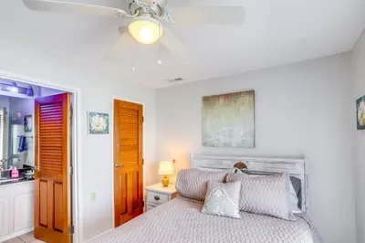 a bedroom with a bed with a ceiling fan at Cozy Lakefront Middle Bass Retreat with Balcony in Put-in-Bay