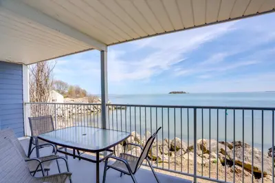 a table and chairs on a balcony with a view of the ocean at Cozy Lakefront Middle Bass Retreat with Balcony in Put-in-Bay