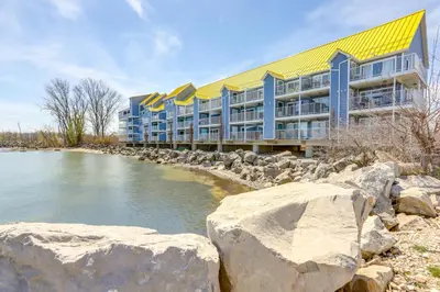 a building with a yellow roof next to a river at Cozy Lakefront Middle Bass Retreat with Balcony in Put-in-Bay