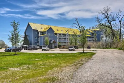 a large blue building with cars parked in a parking lot at Cozy Lakefront Middle Bass Retreat with Balcony in Put-in-Bay