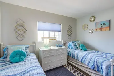 two beds in a bedroom with blue and white at Cozy Lakefront Middle Bass Retreat with Balcony in Put-in-Bay