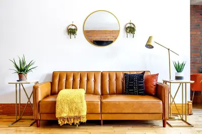 a brown leather couch in a living room with a mirror at Jungle House Luxury Homes - Columbus Downtown Short North - Walk to Convention Center & Nationwide Arena - Sleeps up to 10 - Free Parking - Over 5,800 Five Stars in Columbus