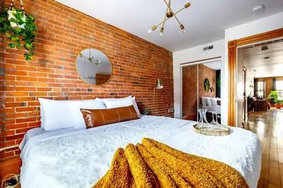 a bedroom with a brick wall and a large bed at Jungle House Luxury Homes - Columbus Downtown Short North - Walk to Convention Center & Nationwide Arena - Sleeps up to 10 - Free Parking - Over 5,800 Five Stars in Columbus