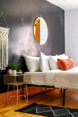 a couch with pillows and a mirror on a wall at Jungle House Luxury Homes - Columbus Downtown Short North - Walk to Convention Center & Nationwide Arena - Sleeps up to 10 - Free Parking - Over 5,800 Five Stars in Columbus