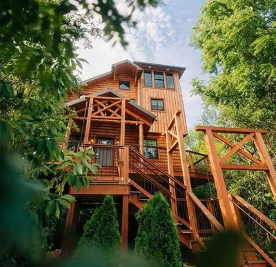 a large wooden house with a large deck at Skyview Treehouse by Amish Country Lodging in Millersburg